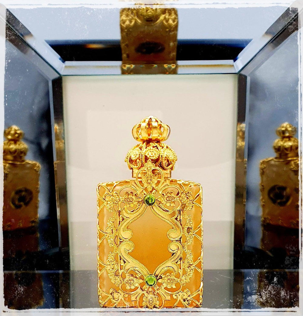Ornate handmade Czech glass flacons crafted in the Jizera Mountains, featuring glass, brass, and colorful jewels. The bottles shine with gold and vibrant gems, perfect for holding oil perfumes